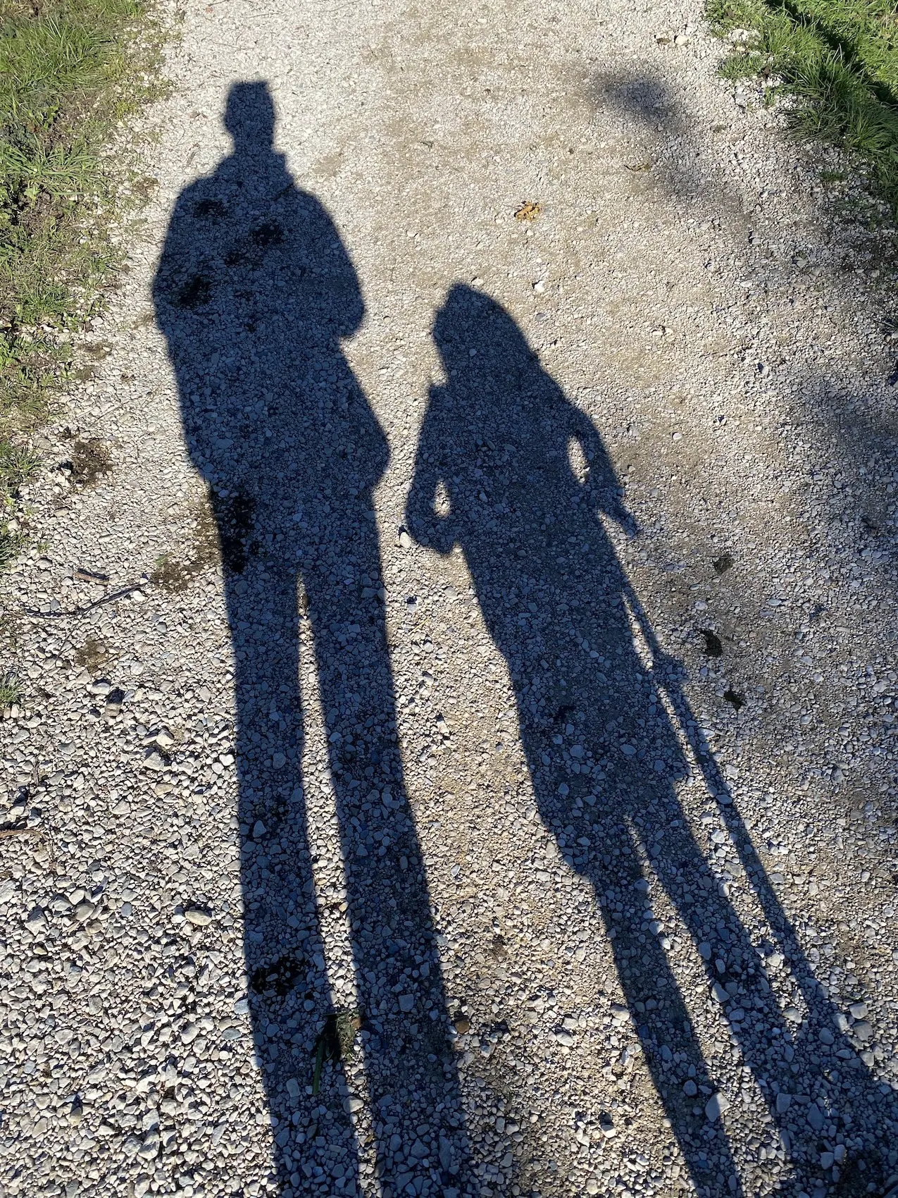 Two shadows on a gravel path: one of my daughters and me
